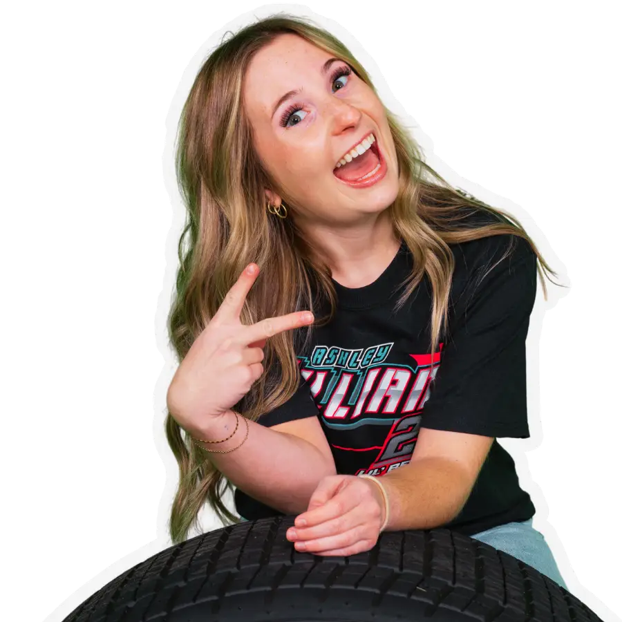 Ashley Williams pointing and smiling over a sprint car tire